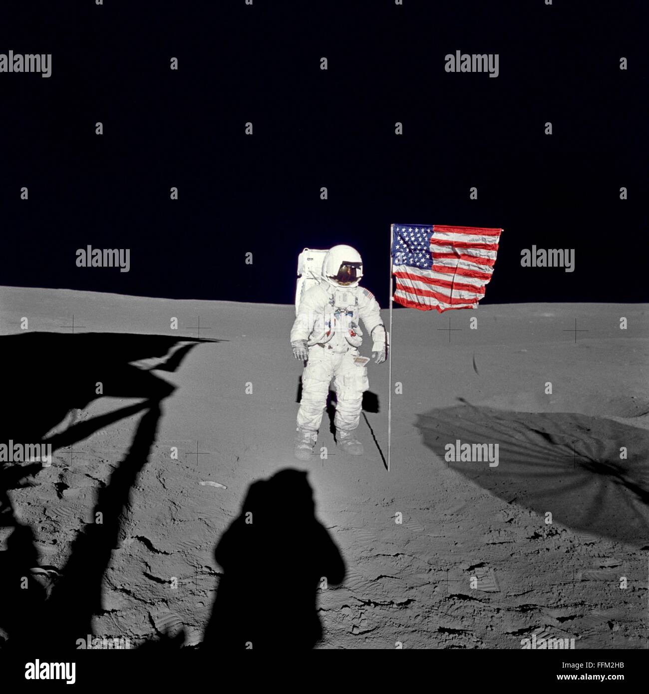 NASA astronaut Edgar D. Mitchell, Apollo 14 lunar module pilot stands by the U.S. flag on the lunar surface during the early moments of the mission's first spacewalk February 5, 1971. Mission commander Alan B. Shepard Jr. is taking the photo in the Fra Mauro region of the moon. Stock Photo