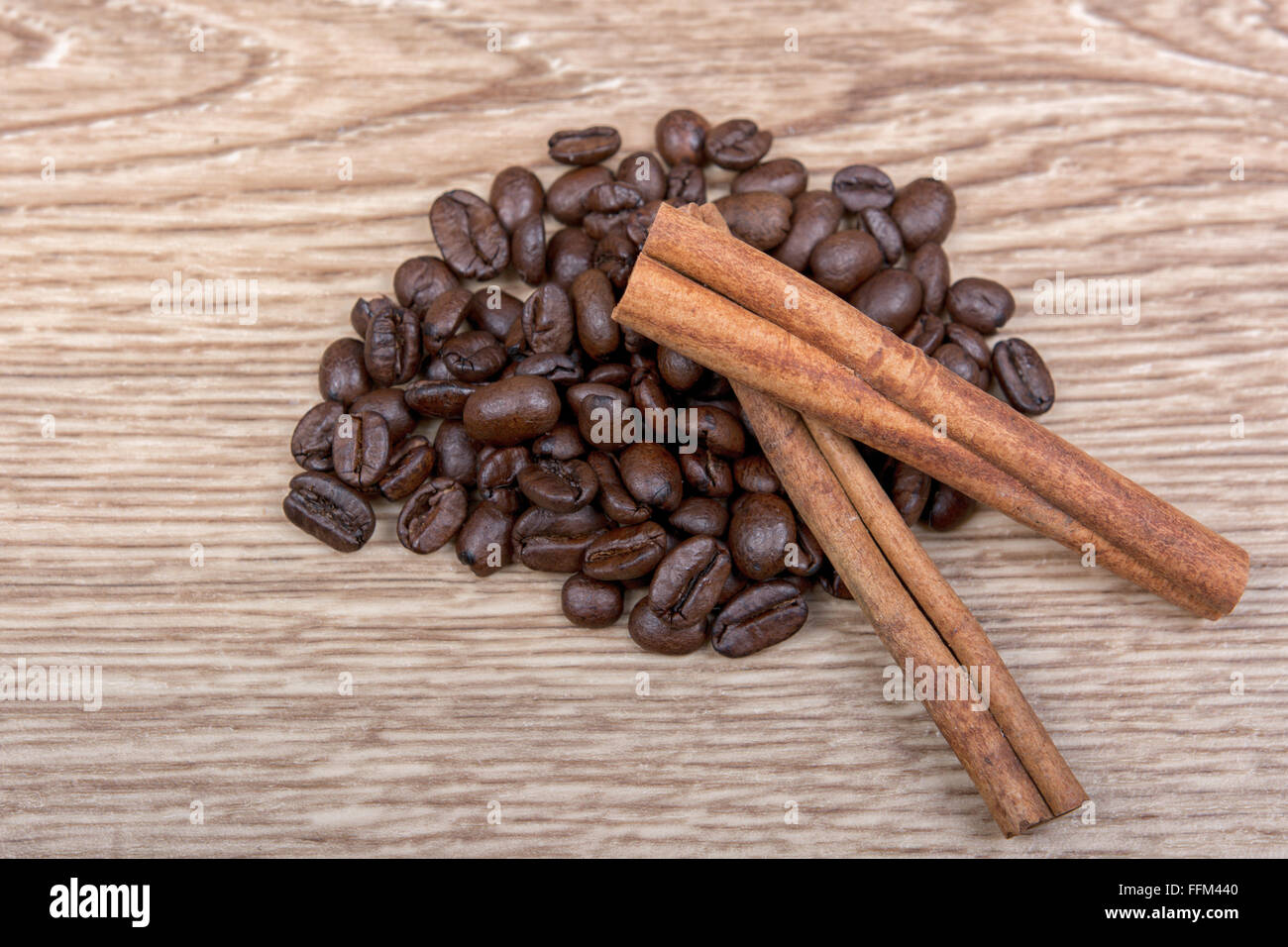 Grains of coffee with cinnamon on a wooden background Stock Photo
