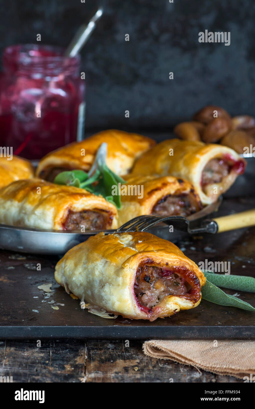 Homemade pork sausage rolls with chestnuts, cranberry sauce and sage Stock Photo