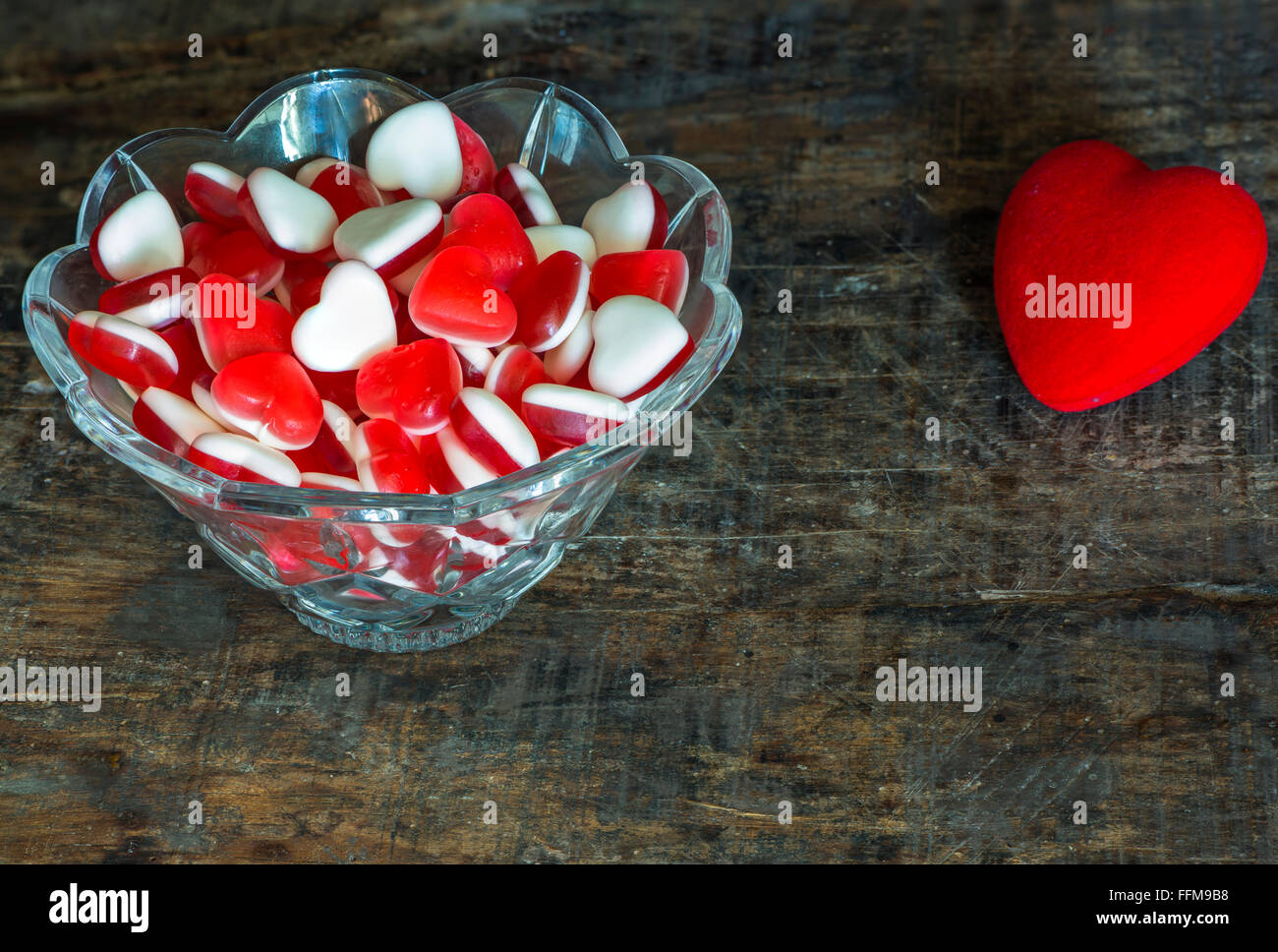 Fruit jelly hearts in a crystal bowl on dark vintage background Stock