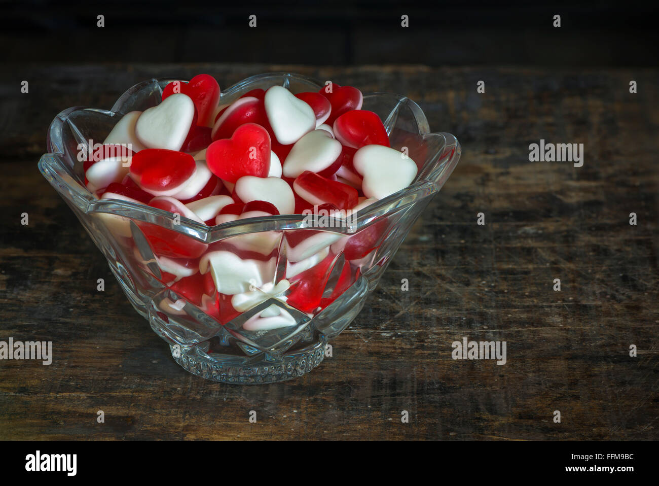 Fruit jelly hearts in a crystal bowl on dark vintage background Stock
