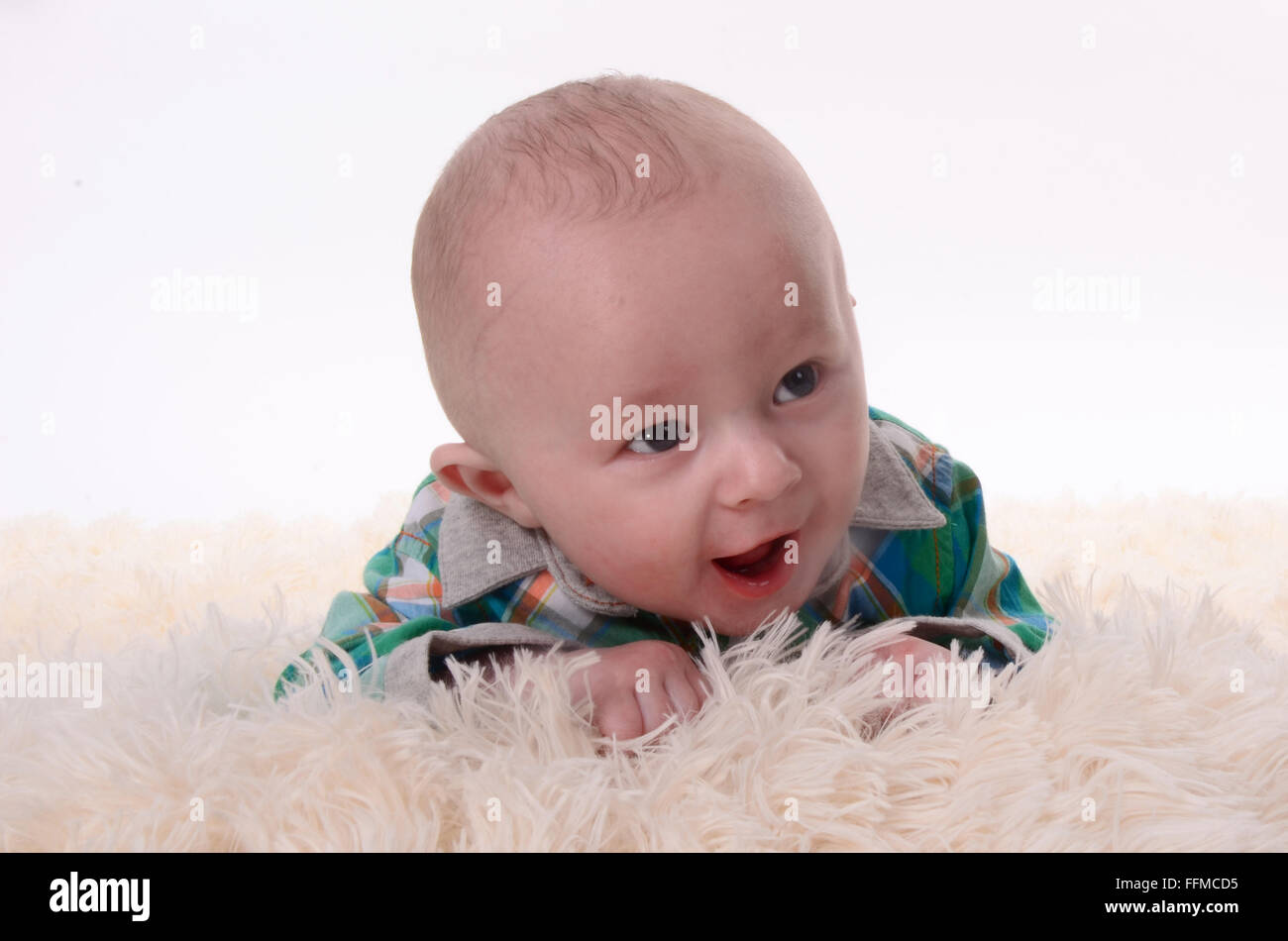 happy baby laughing on rug Stock Photo