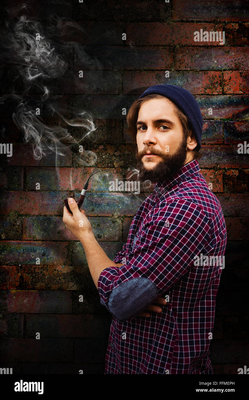 Composite image of side view of hipster holding smoking pipe Stock Photo