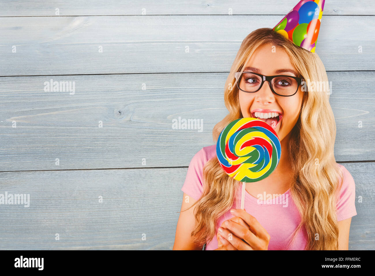 Composite image of a beautiful hipster holding a giant lollipop Stock Photo