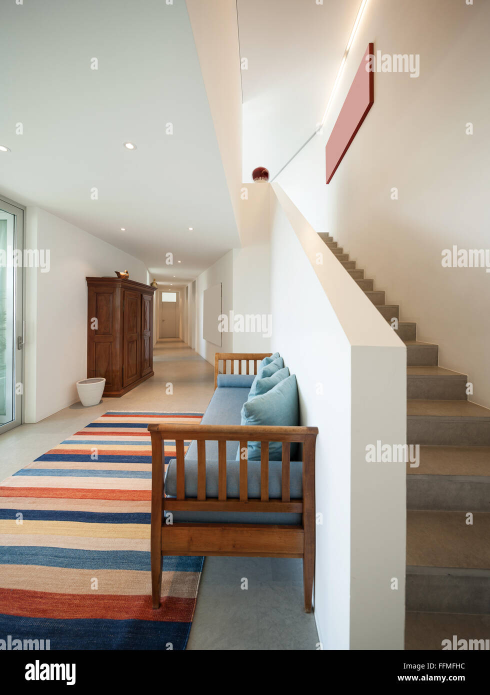 Interior of a modern house, hall with divan and striped rug Stock Photo ...