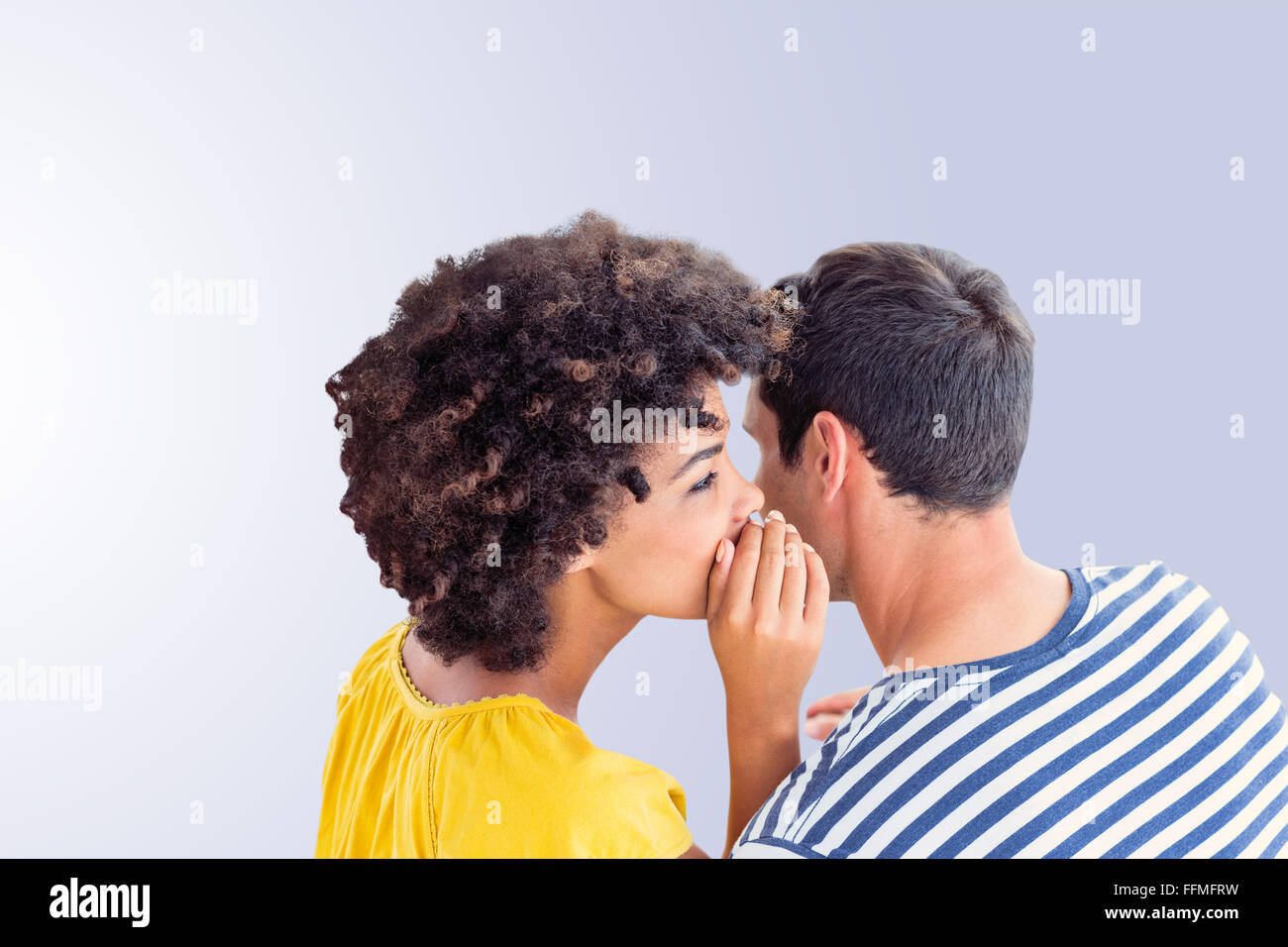 Composite image of couple whispering in ear Stock Photo