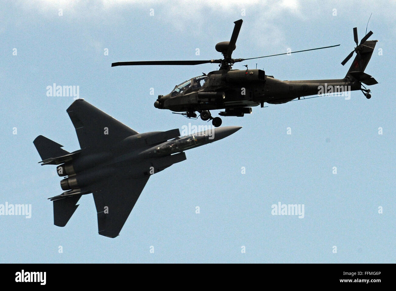 Singapore. 16th Feb, 2016. A F-15SG fighter plane (L) and a AH-64D Apache attack helicopter of Singapore Air Force perform aerobatic flying during the Singapore Airshow held at Singapore's Changi Exhibition Centre, Feb. 16, 2016. The Singapore Airshow, Asia's largest and one of the most important aerospace and defence exhibitions in the world, kicked off Tuesday with a renewed focus on driving global aviation industry trends and developments. Credit:  Then Chih Wey/Xinhua/Alamy Live News Stock Photo