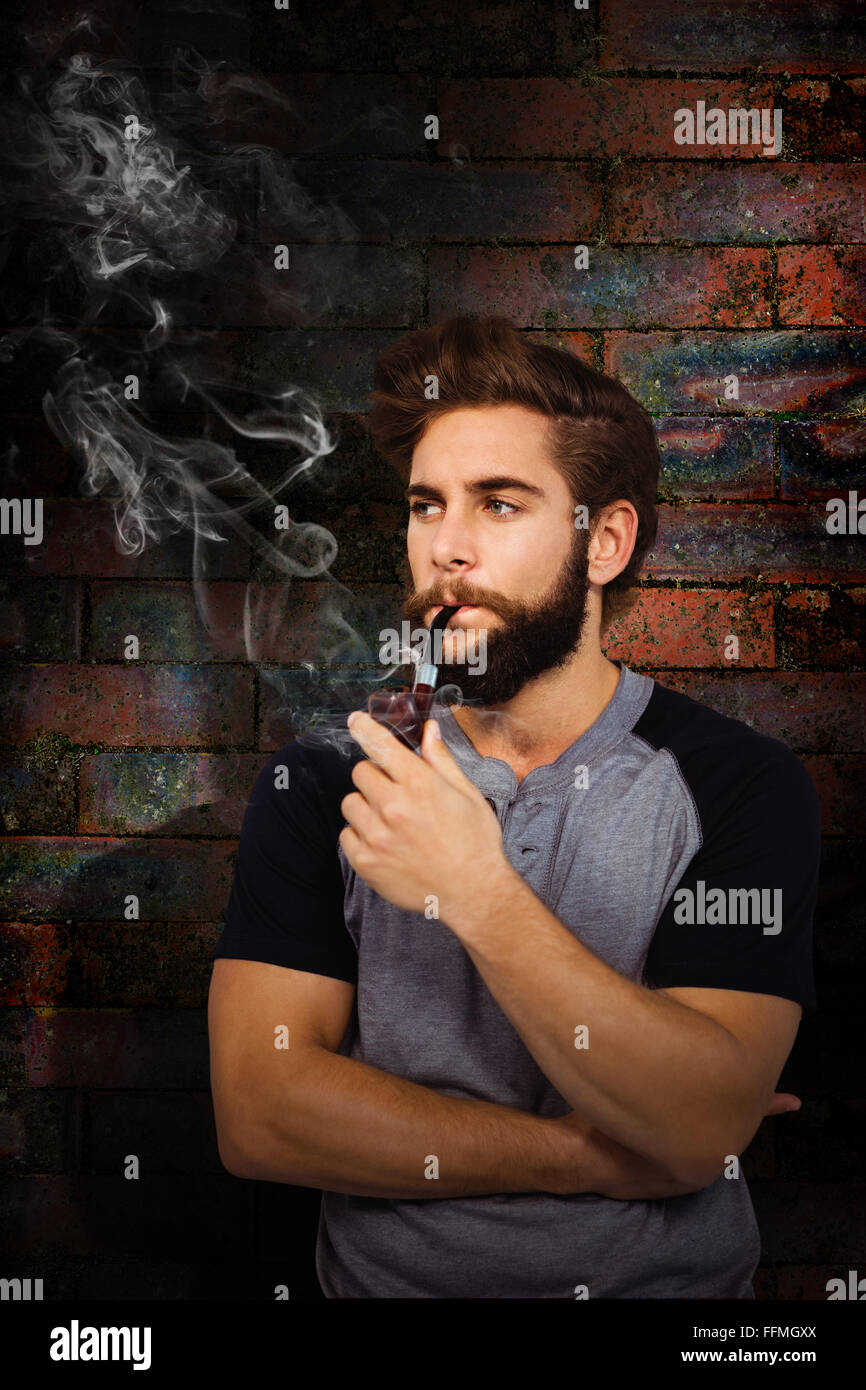 Composite image of confident hipster smoking pipe Stock Photo