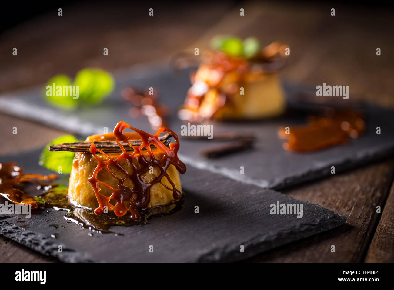 Caramel pudding dessert with vanilla, mint and caramel decoration Stock