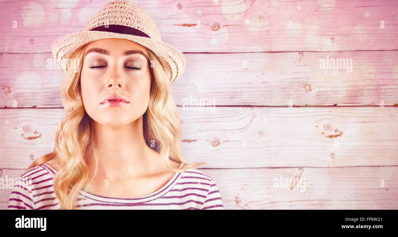 Composite image of gorgeous blonde hipster with straw hat Stock Photo