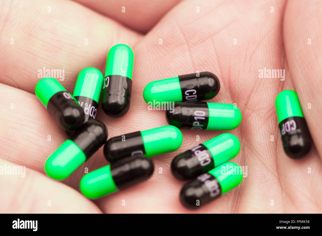 10 Valium tablets (chlordiazepoxide) in the palm of a hand.  This is a high dose (100mg) which would incapacitate most people. Stock Photo
