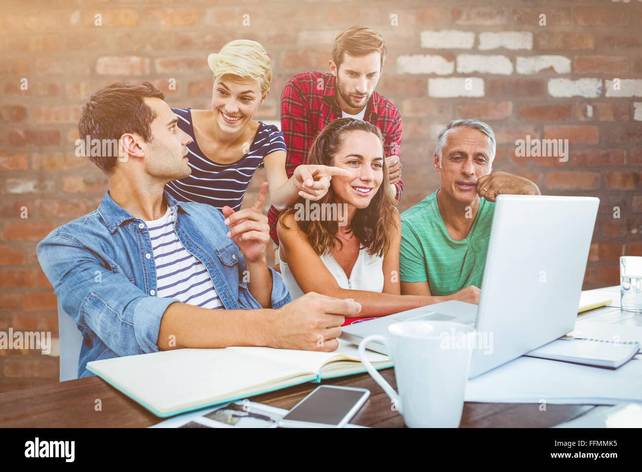Composite image of creative business team using laptop in meeting Stock ...