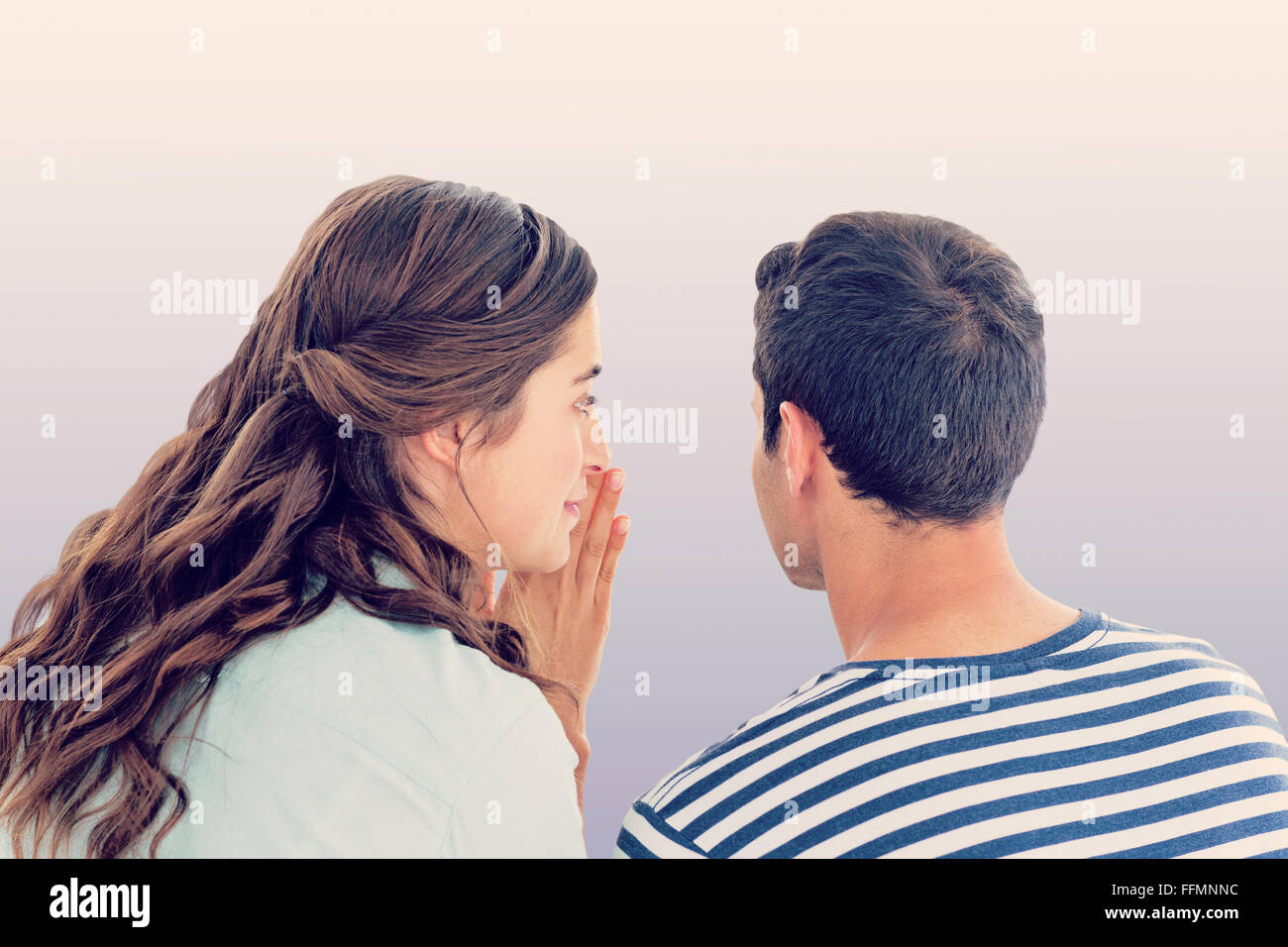Composite image of woman whispering secret to boyfriend Stock Photo