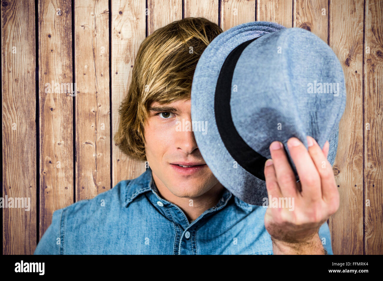 Composite image of focused hipster man hiding his face Stock Photo
