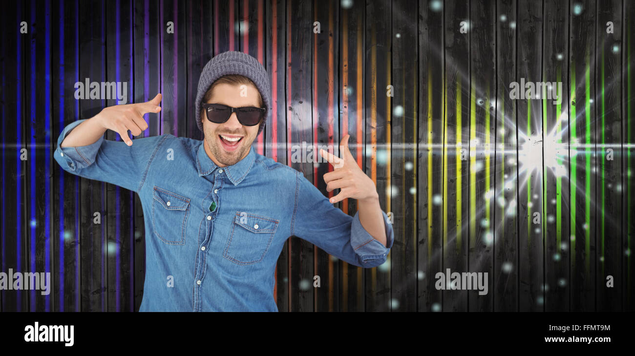 Composite image of happy hipster showing rock and roll hand sign Stock Photo