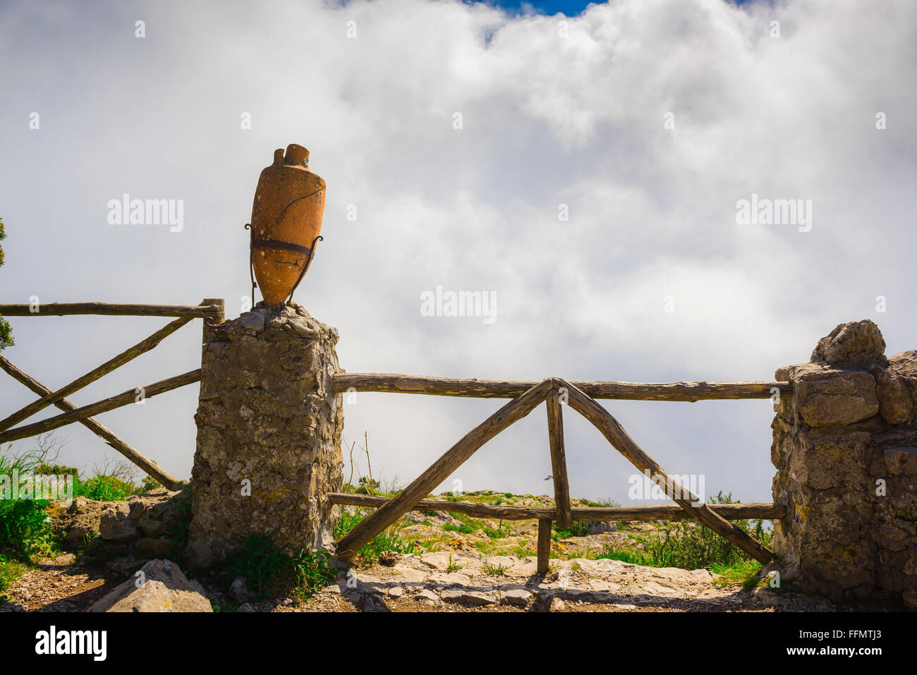 Fence sky clouds, view of a fence at Monte Solaro offering protection from the sheer drop of the cliff beyond it, Capri island, Campania, italy. Stock Photo