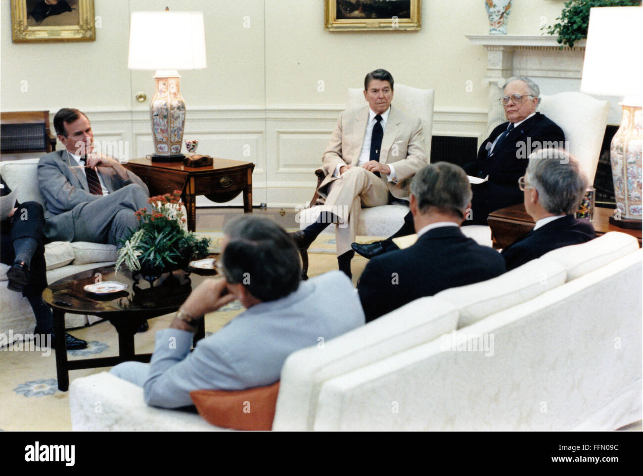 Washington, District of Columbia, USA. 23rd Nov, 2009. United States President Ronald Reagan meets in the Oval Office with members of the Foreign Intelligence Advisory Board on Tuesday, July 14, 1987. Seated, clockwise, from left, are: U.S. Vice President George H.W. Bush, President Reagan, Leo Cherne, James Wilson, John Foster, and White House Chief of Staff Howard Baker.Meeting .Mandatory Credit: Pete Souza - White House via CNP © Pete Souza/CNP/ZUMA Wire/Alamy Live News Stock Photo