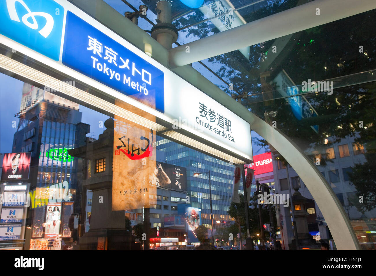 A twilight wide-angle view shows the Tokyo Metro Subway entrance at Aoyama Dori Avenue and Omotesando Avenue in the upscale Stock Photo