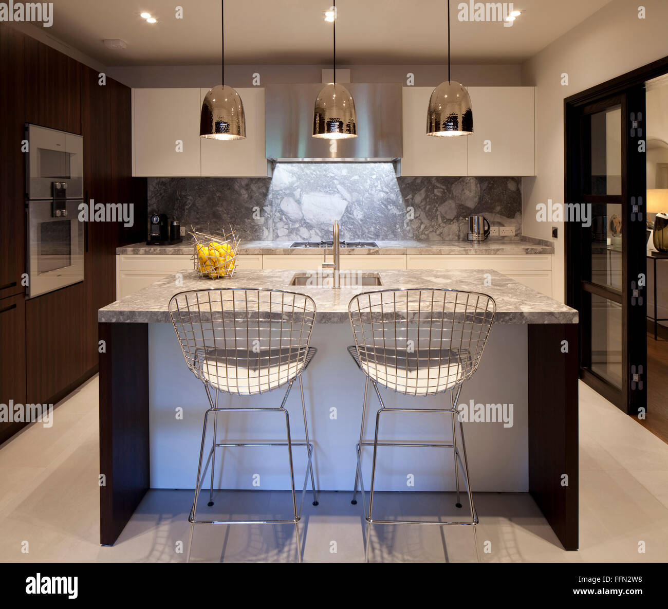 Knightsbridge Apartment, London. The kitchen with dark wood cupboards and white surfaces. Stock Photo