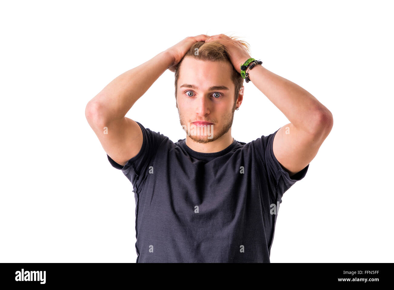 Young bearded man with hands on head looks puzzled. Isolated, white background. Stock Photo