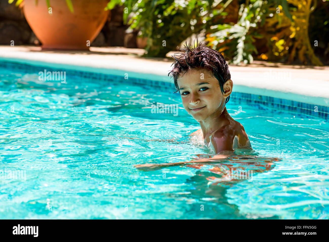 Boy kid child eight years old inside swimming pool portrait happy fun bright day Stock Photo