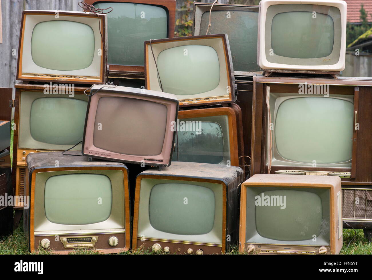 broadcast,television,old German television sets by  Neckermann,Saba,Grätz,Philips,Nordmende,Vega,Germany,1950s and 1960s,piled  in the meadow,television wall,wall of tv sets,monitor wall,wall of monitors,television  collection,collection of tv sets ...