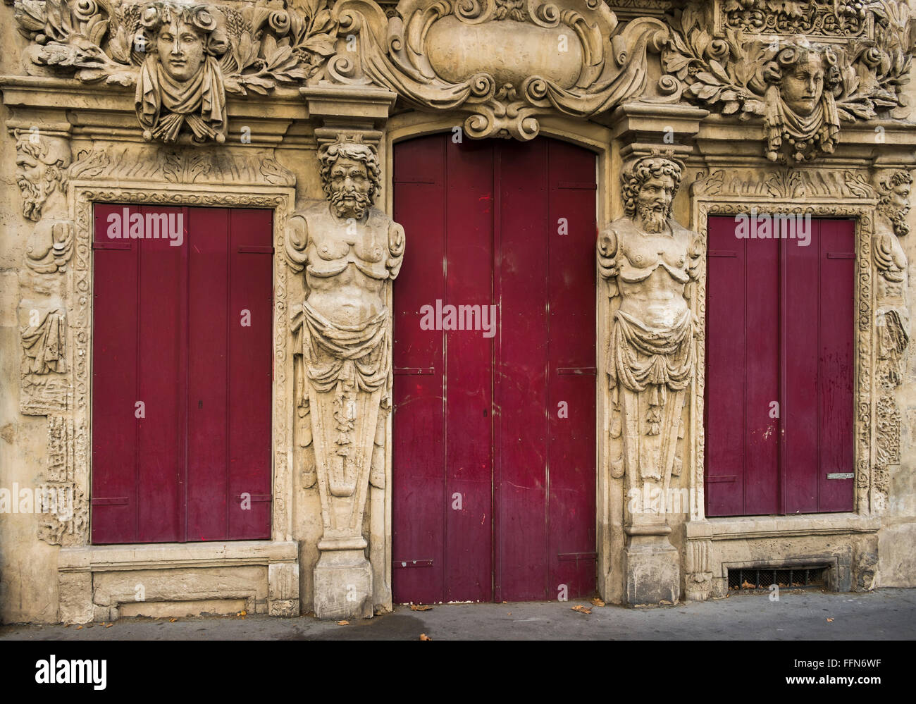 opulently decorated facade, red wooden doors and shutters Stock Photo