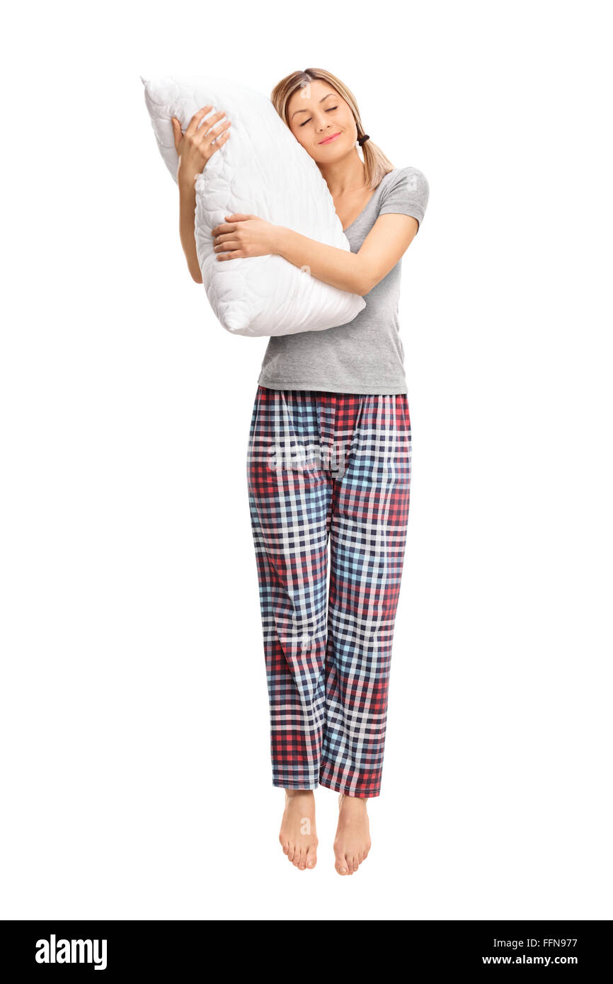 Full length portrait of a calm woman hugging a pillow and sleeping shot in mid-air isolated on white background Stock Photo