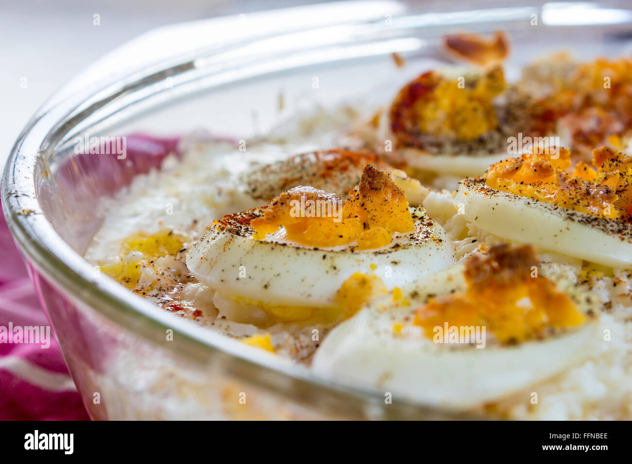 Romanian polenta (mamaliga) with eggs in a pyrex dish Stock Photo