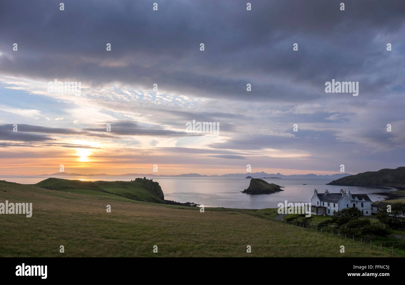 duntulm bay & castle with islet & hotel at sunset with harris on horizon Stock Photo