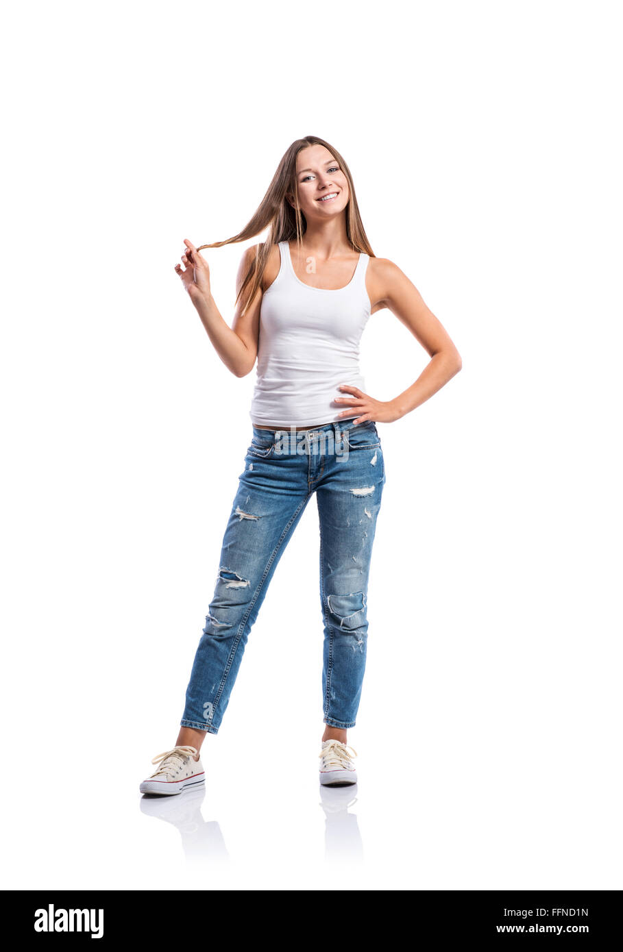 Woman in jeans and white singlet twirling hair,  isolated Stock Photo