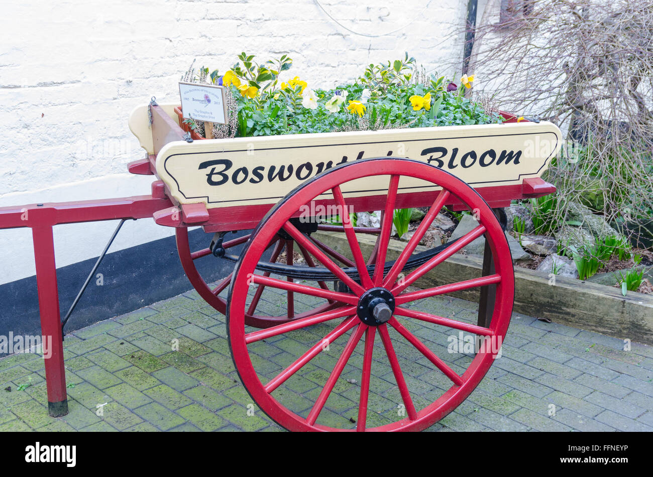 Old wooden wheel barrow containing plants to mark 'Bosworth in Bloom' Stock Photo