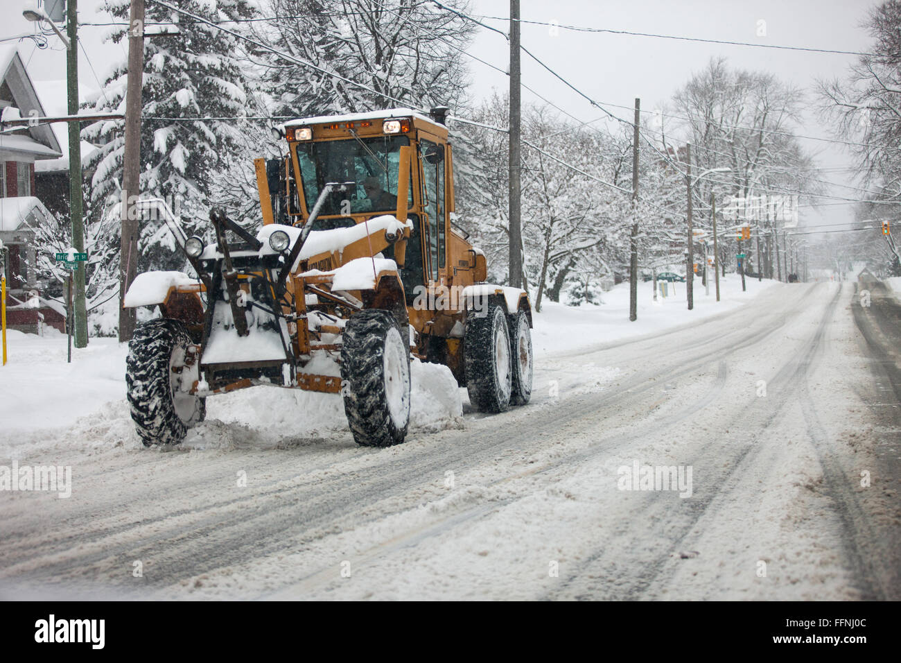 A snow plow works at clearing streets in London Ontario, Canada on