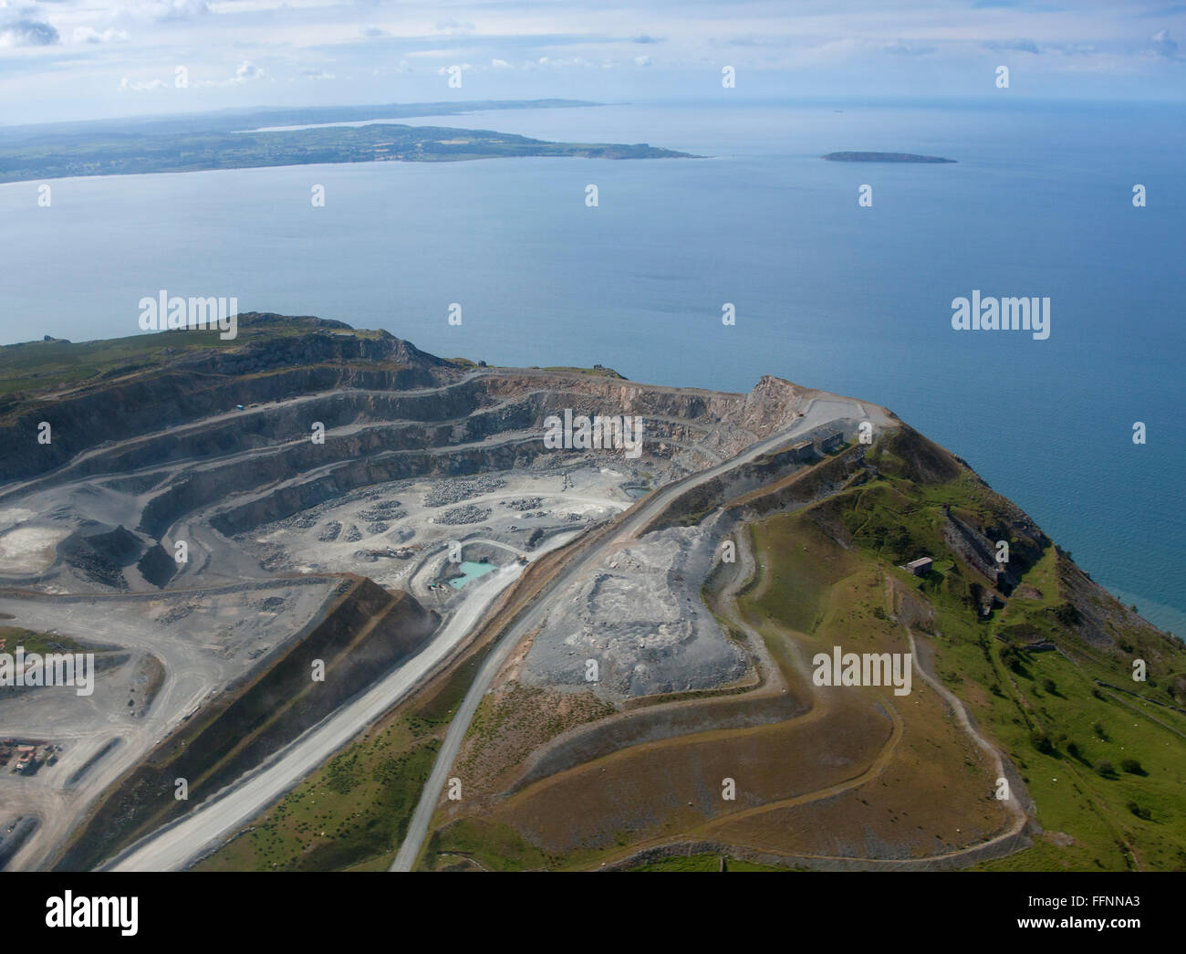 Aerial view of Penamenmawr stone quarry on Penmaenmawr mountain overlooking Conwy Bay, view to Anglesey and Puffin Island Conwy Stock Photo