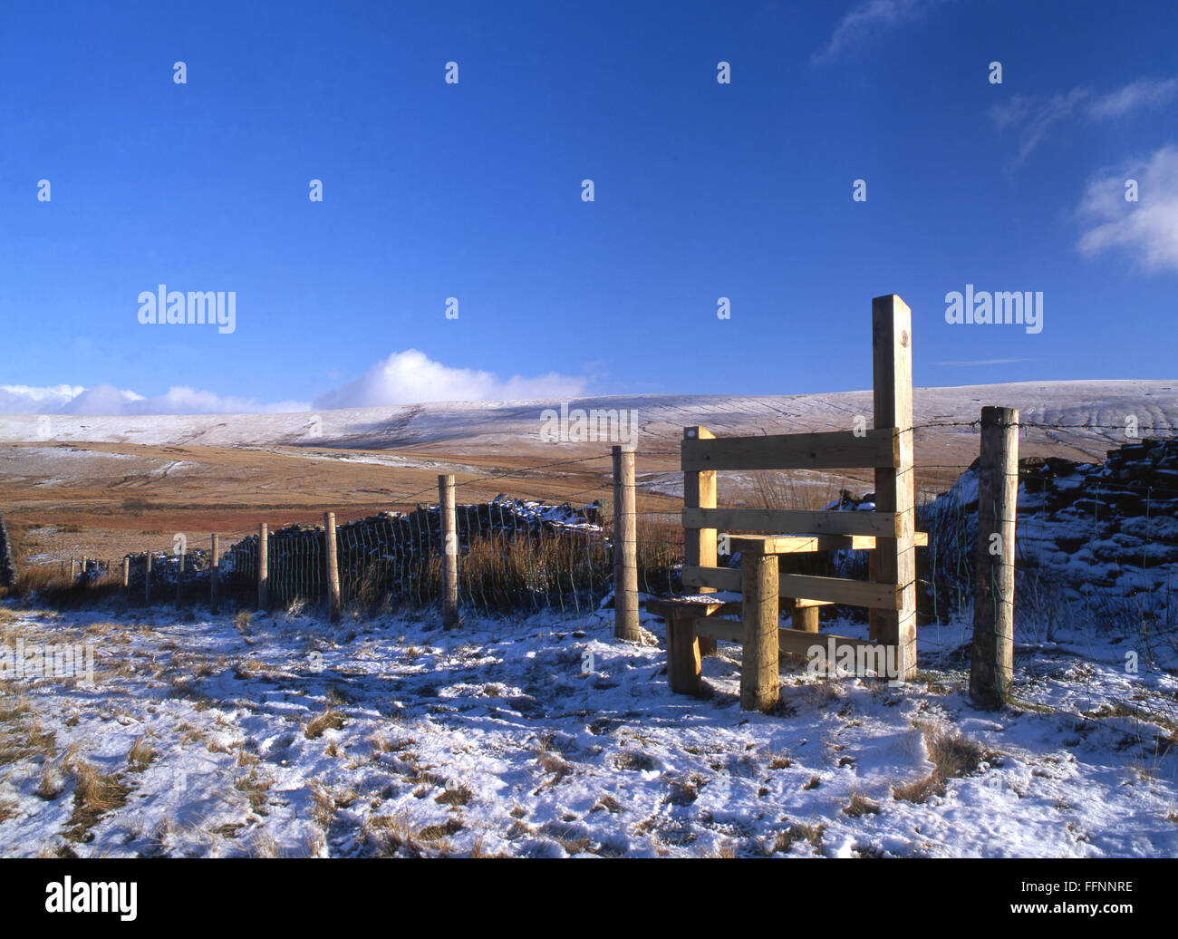 Wooden stile and fence in snow Blaen Llia in background Fforest Fawr Geopark Brecon Beacons National Park Powys Wales UK Stock Photo