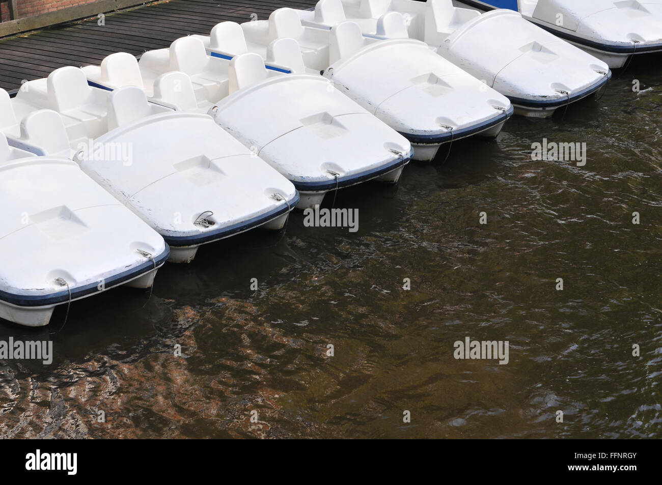 Six white paddle boats for rent in Amsterdam canal Stock Photo Alamy
