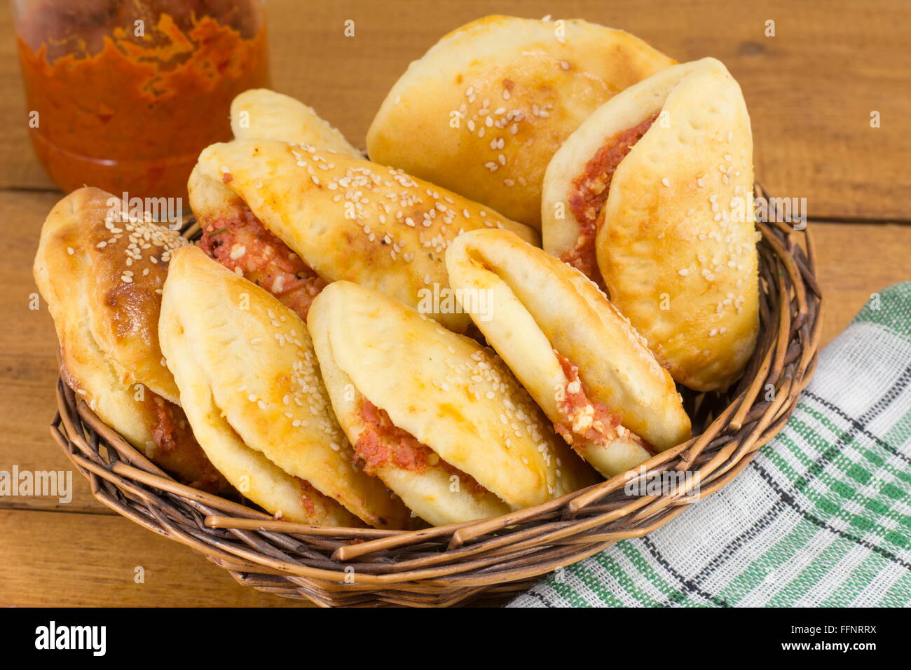 pizza buns with small sausages and pepperoni in a wooden basket Stock Photo