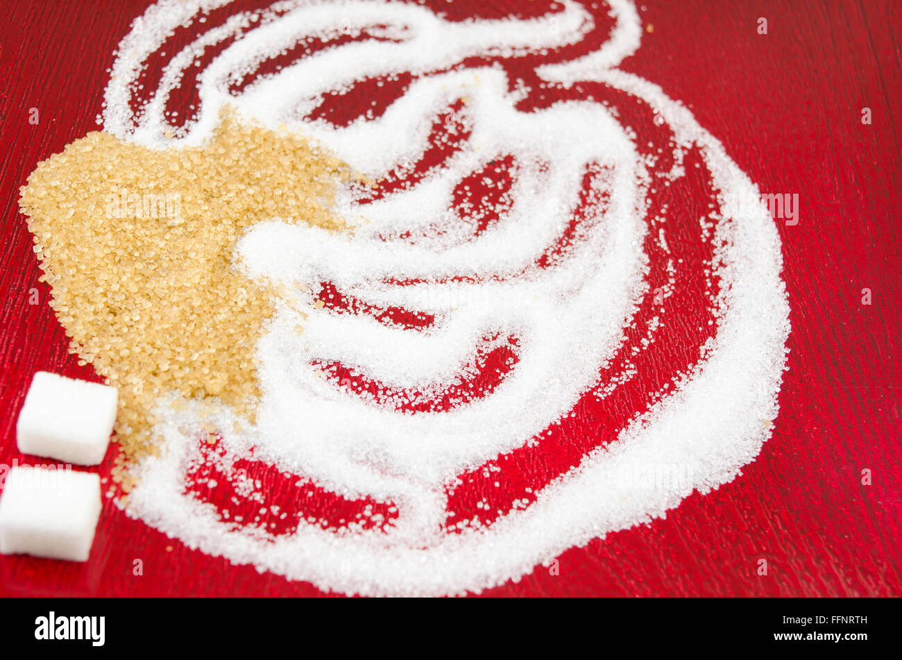 White and brown sugar shapes  on red background Stock Photo