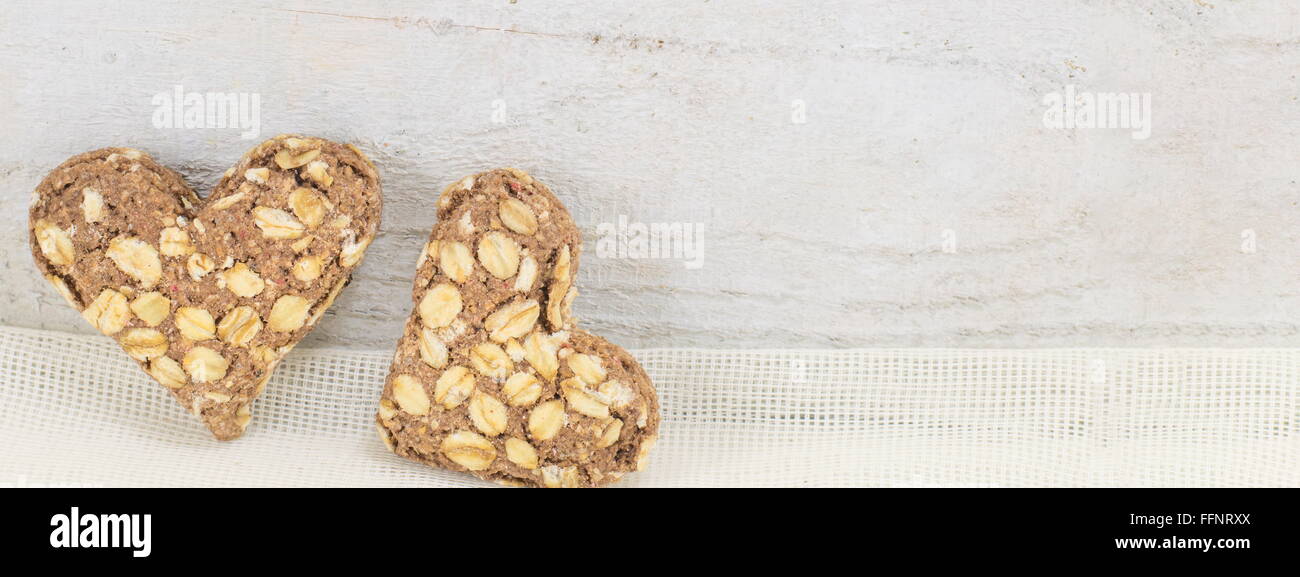 whole wheat flour hearts filled with seeds on a wooden surface Stock Photo