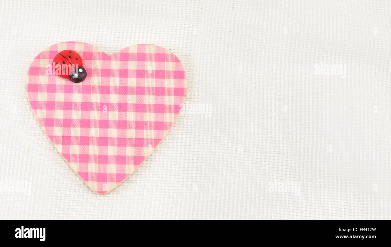 pink plaid heart with a ladybug on white background Stock Photo