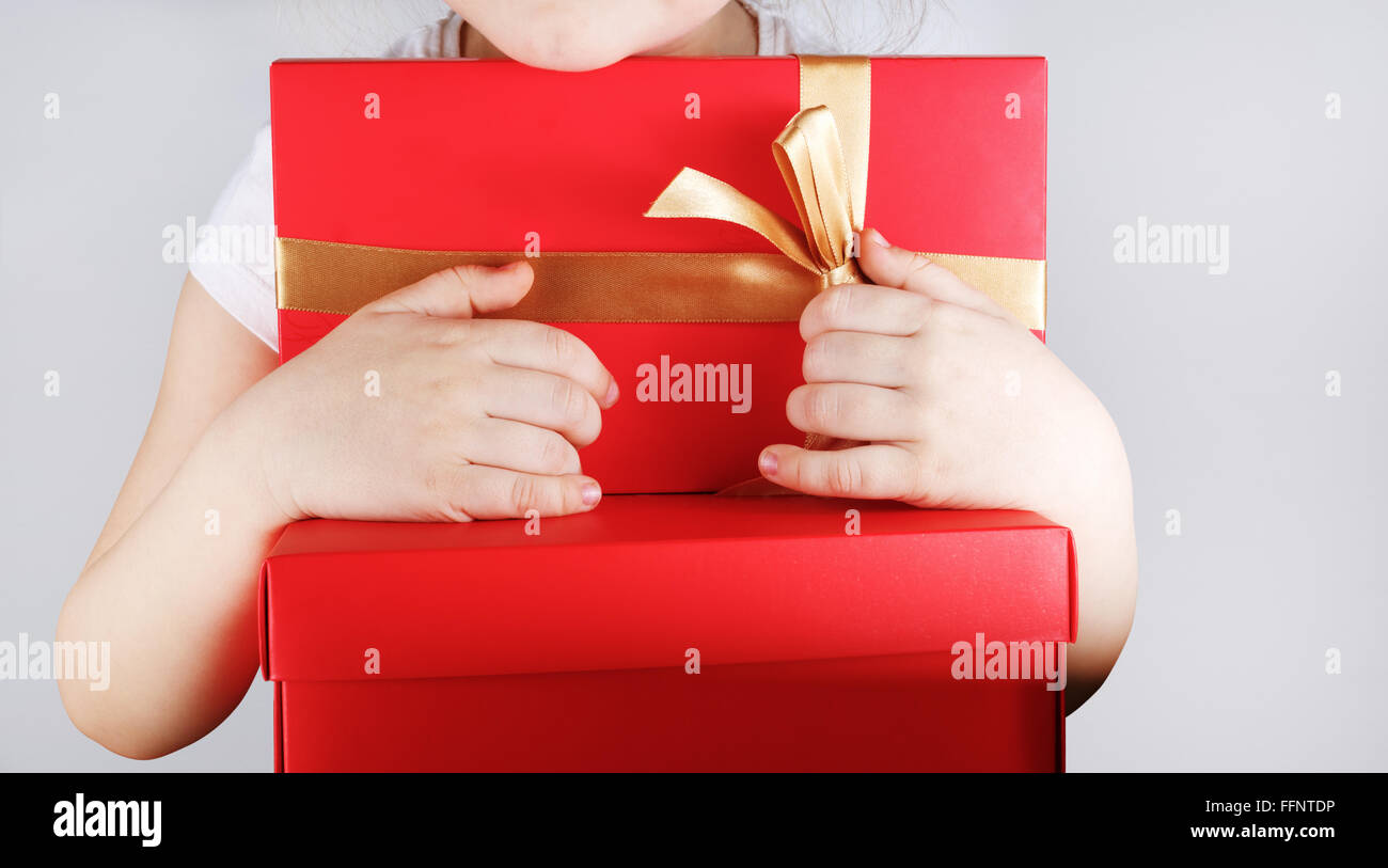 Big red gift box in the children hands. Child holding red gift box with ...
