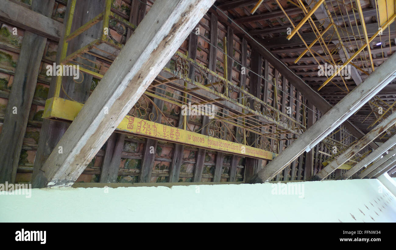 Ceiling structure supporting metal benches with inscriptions at temple in Asia Stock Photo