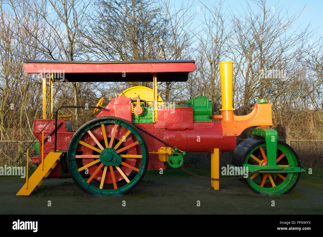 A brightly painted antique steamroller provides a colourful climbing frame in a children’s playground. Dorchester, Dorset, England, United Kingdom. Stock Photo