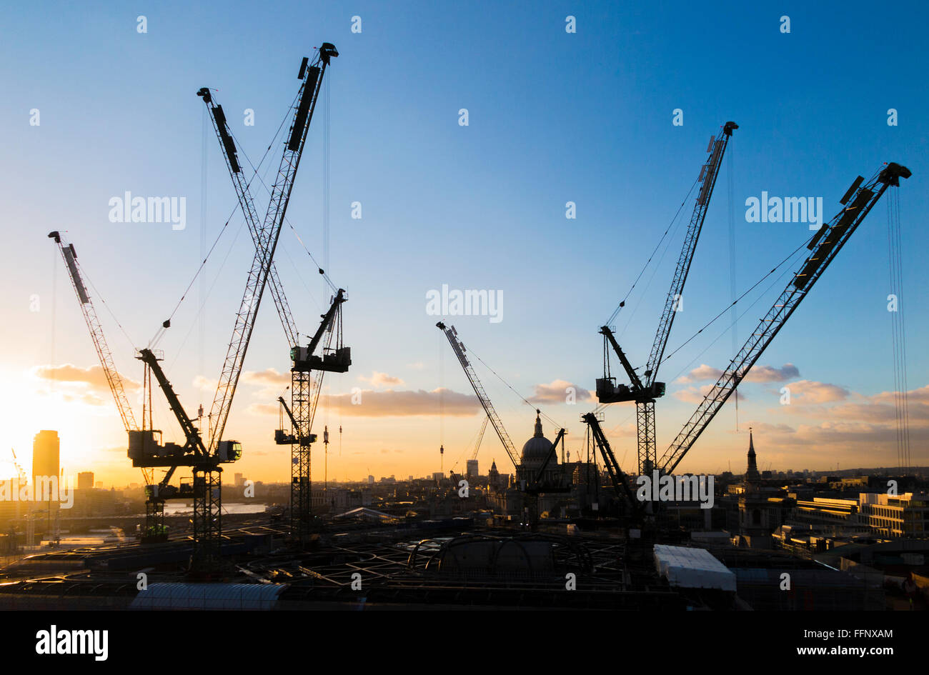 Tower cranes on the new Bloomberg Place office development in the City of London, EC4 silhouetted on the skyline at sunset Stock Photo