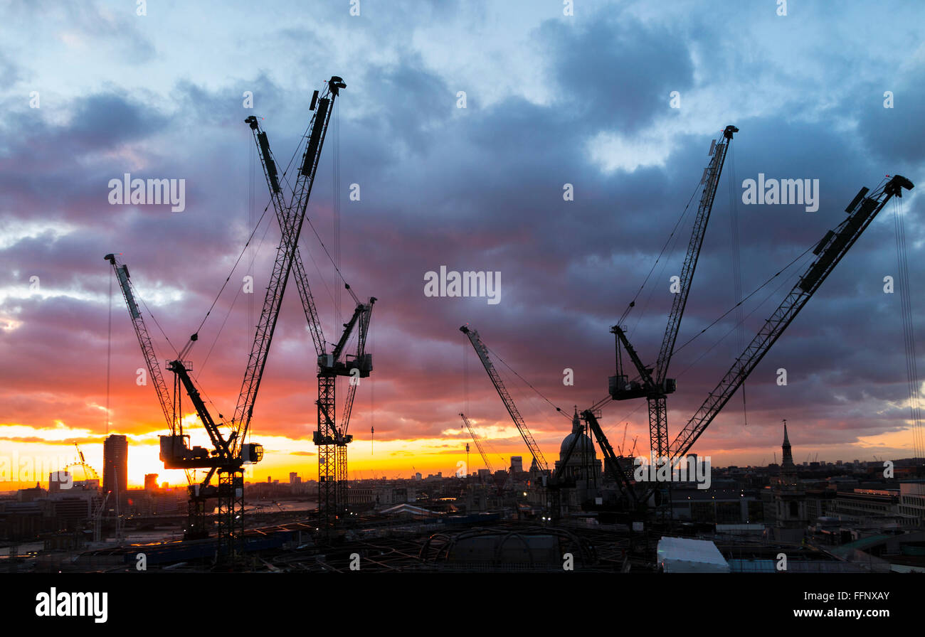 Tower cranes on the new Bloomberg Place office development in the City of London, EC4 silhouetted on the skyline at sunset Stock Photo