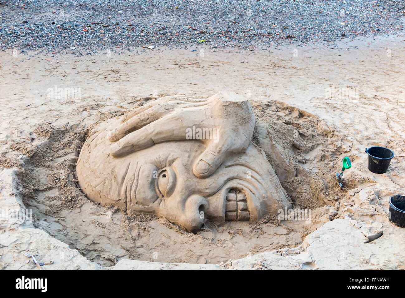 Sand sculpture of an ugly head on the south bank of the Embankment at