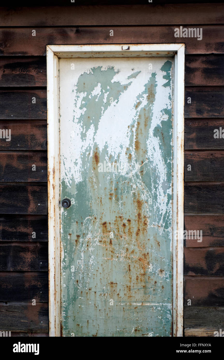 Pitted metal door with rust and peeling paint Stock Photo