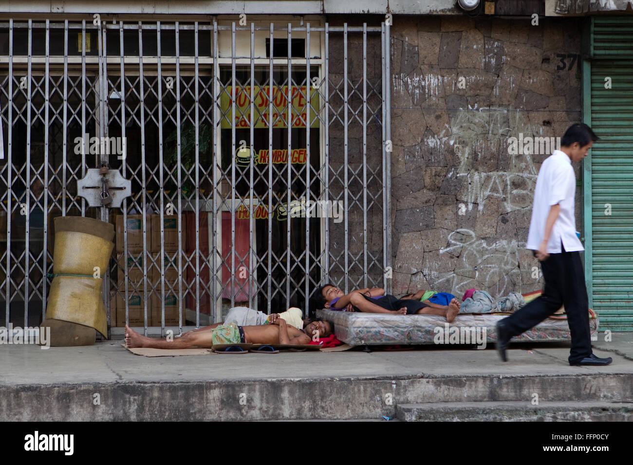 Within Philippine Cities homeless people,which include children & entire families can be seen sleeping on sidewalks. Stock Photo