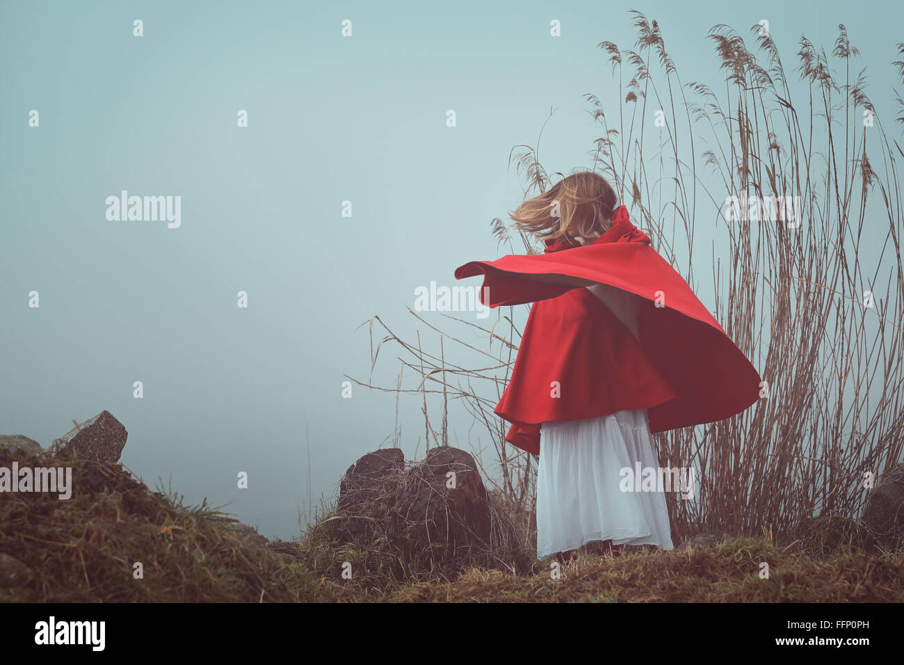 Dark and surreal  portrait of a red hooded woman . Sadness and loneliness conceptual Stock Photo