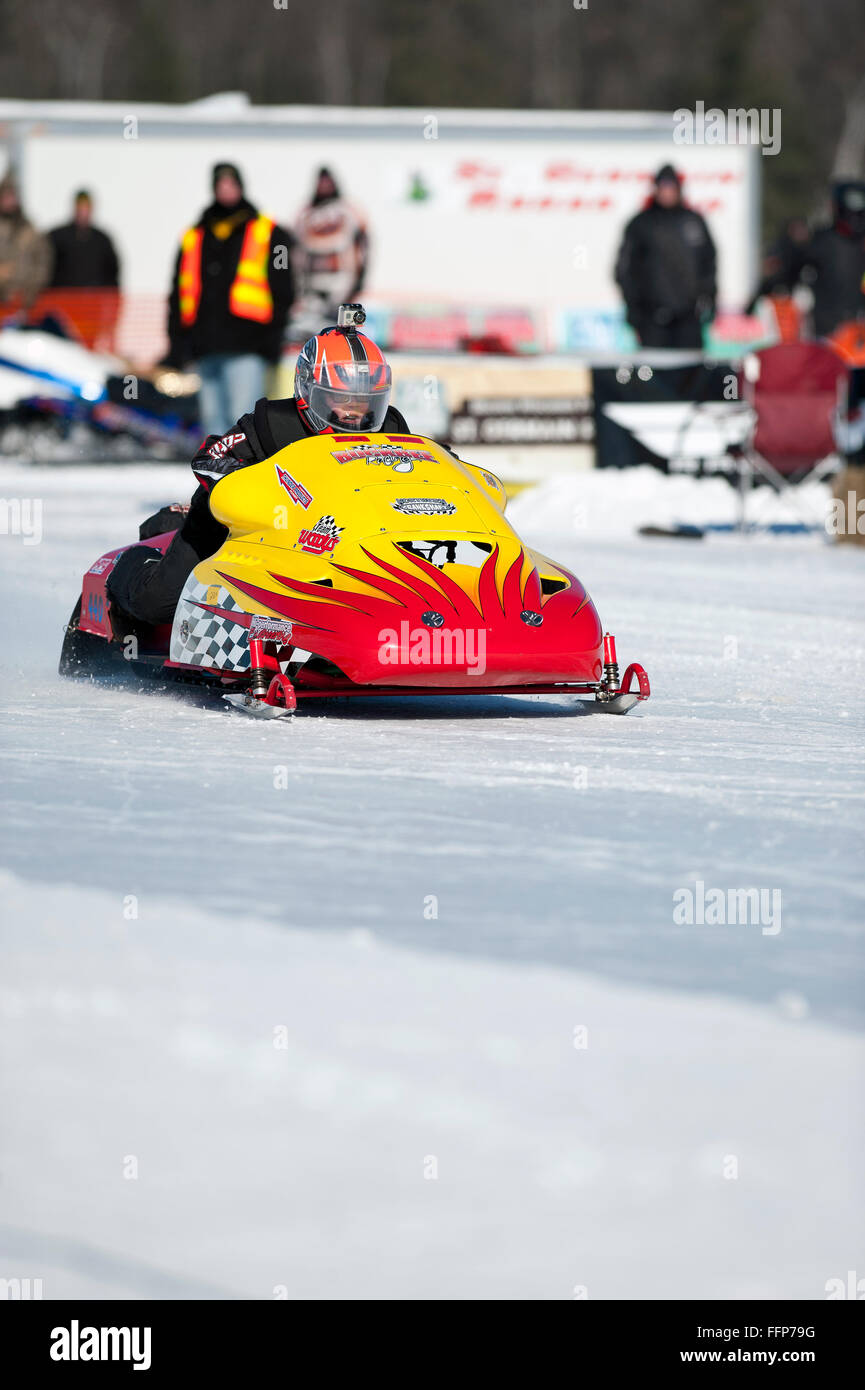 Braxton Buckbee races his snowmobile down a 1,000-foot shaved ice track during a radar run event. Stock Photo